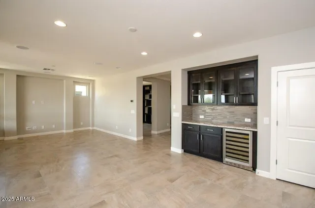 an empty room with kitchen and front door