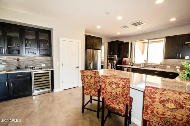a kitchen with stainless steel appliances kitchen island granite countertop a stove a sink and a refrigerator