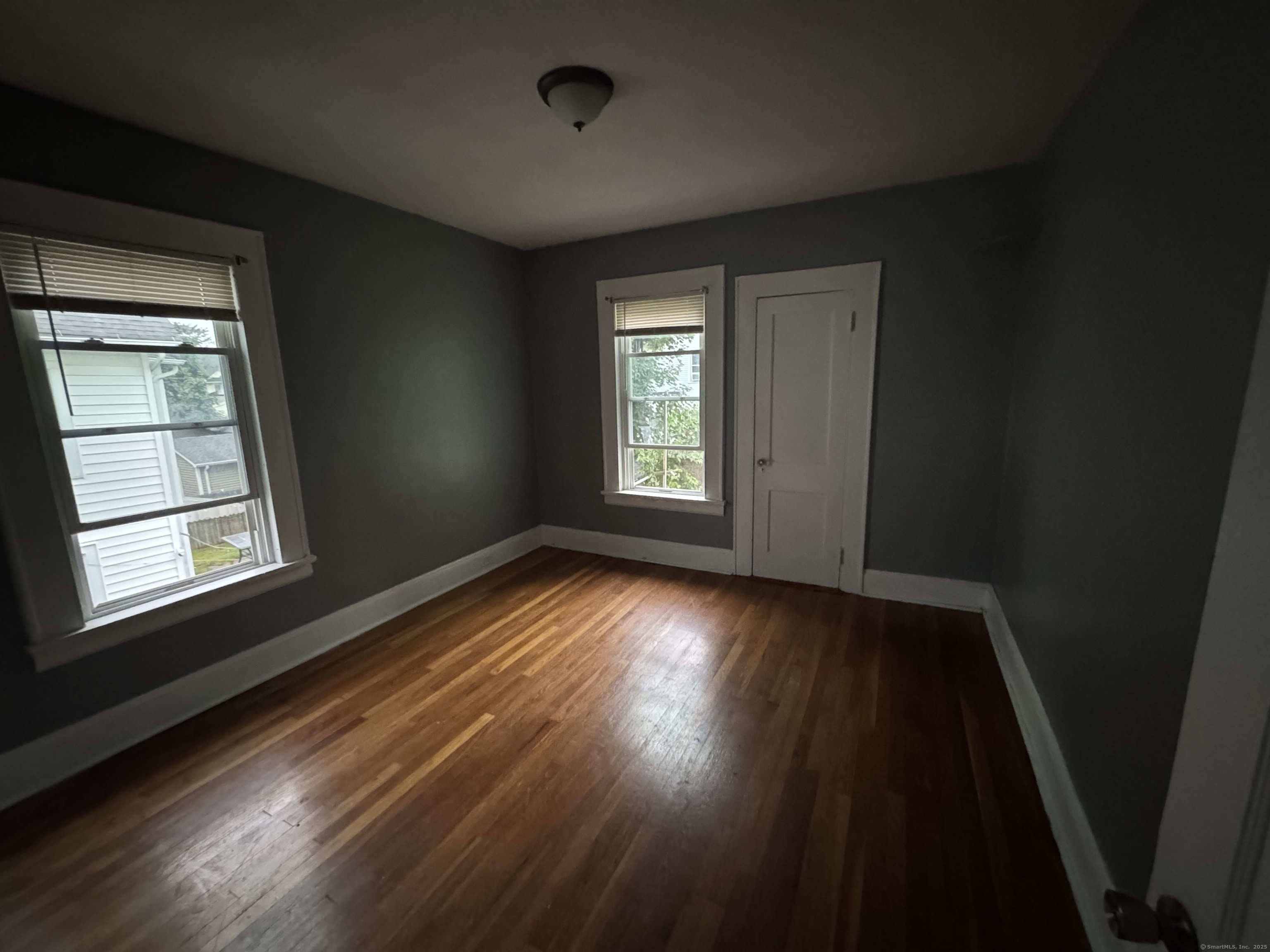 65 Palm Street Bridgeport, CT 06610 - Photo 6 of 13 an empty room with wooden floor and windows