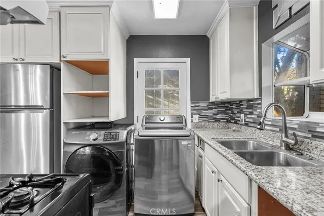 a kitchen with stainless steel appliances granite countertop a stove a sink and a refrigerator