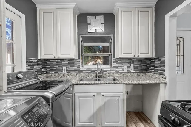 a kitchen with stainless steel appliances granite countertop a sink stove and cabinets