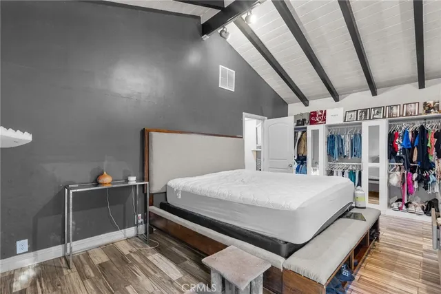 a bedroom with a bed and a large mirror on the dresser