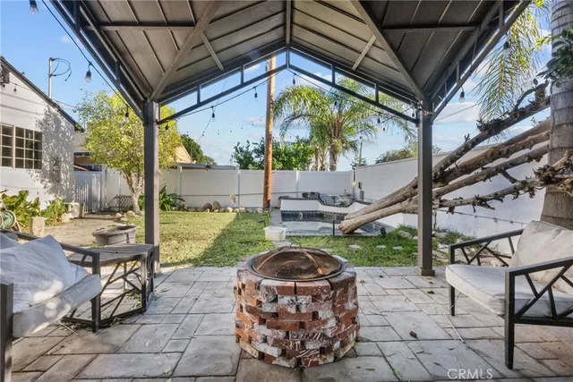 a view of a patio with table and chairs potted plants with wooden floor and fence