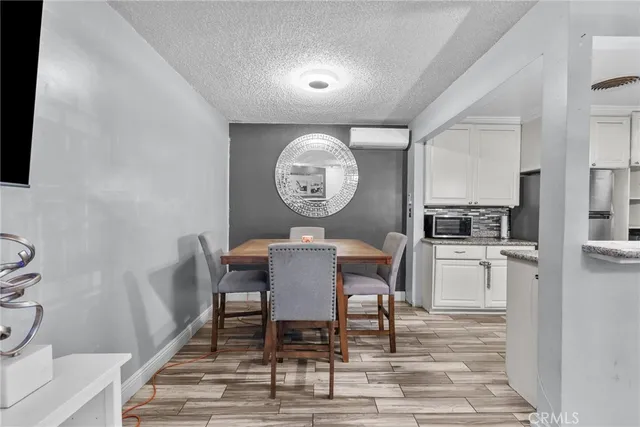 a view of a dining room and kitchen with furniture a rug and wooden floor