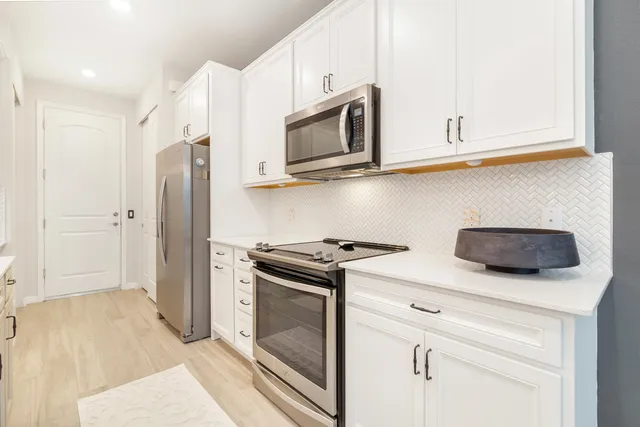 a kitchen with stainless steel appliances white cabinets and a stove