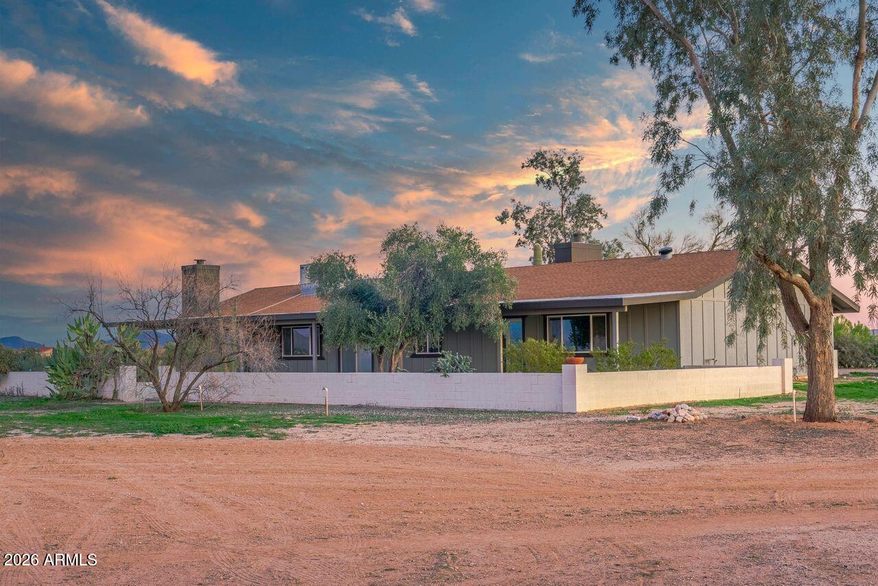 51718 West Donald Road Aguila, AZ 85320 - Photo 34 of 59 a front view of a house with a garden and trees