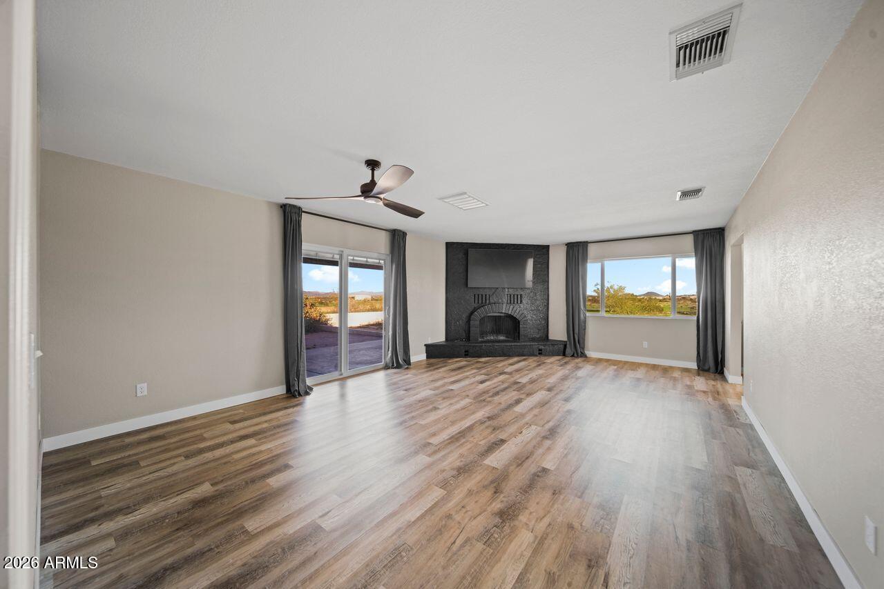 51718 West Donald Road Aguila, AZ 85320 - Photo 10 of 59 a view of empty room with wooden floor and a window