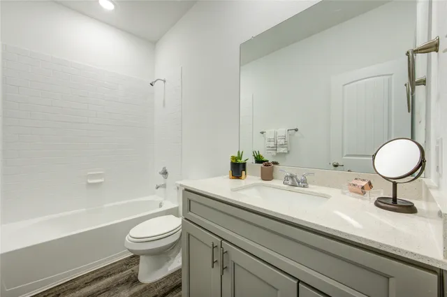 a bathroom with a granite countertop sink mirror vanity and toilet