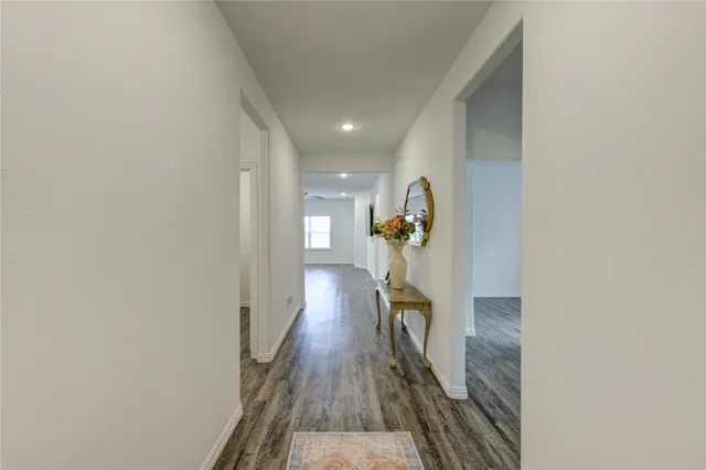 a view of a hallway with wooden floor and a potted plant