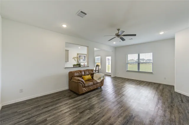 a living room with furniture and a ceiling fan