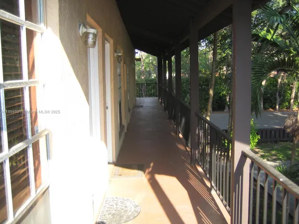 a view of a house with a small yard plants and a large tree