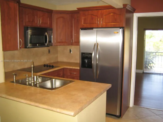 a kitchen with stainless steel appliances wooden cabinets a sink and a microwave