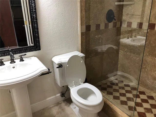 a bathroom with a sink toilet and shower