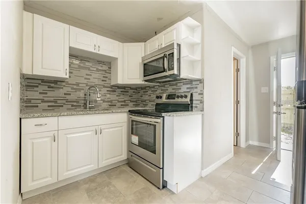 a kitchen with stainless steel appliances granite countertop white cabinets and a granite counter tops