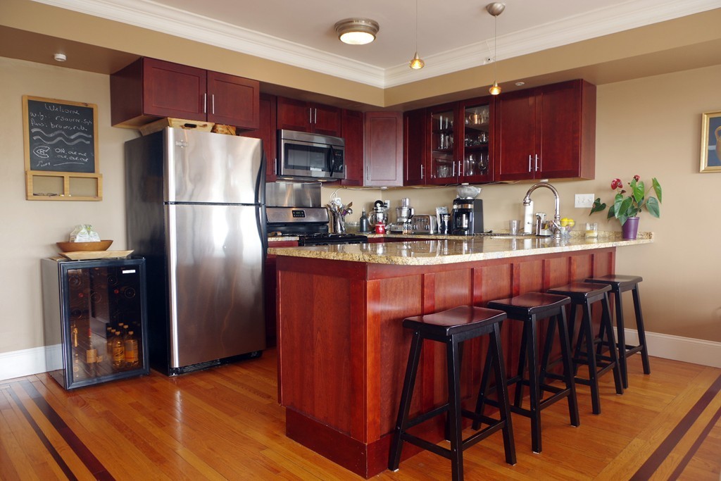 39 Juliette Street, Unit 3 Boston, MA 02122 - Photo 9 of 20 a kitchen with granite countertop a refrigerator a stove a sink and a dining table