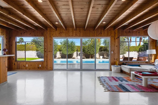 a living room with furniture and a floor to ceiling window