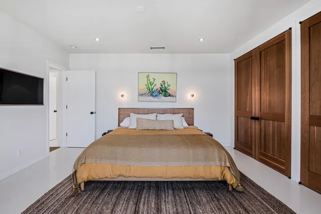 a bedroom with a bed and a flat screen tv