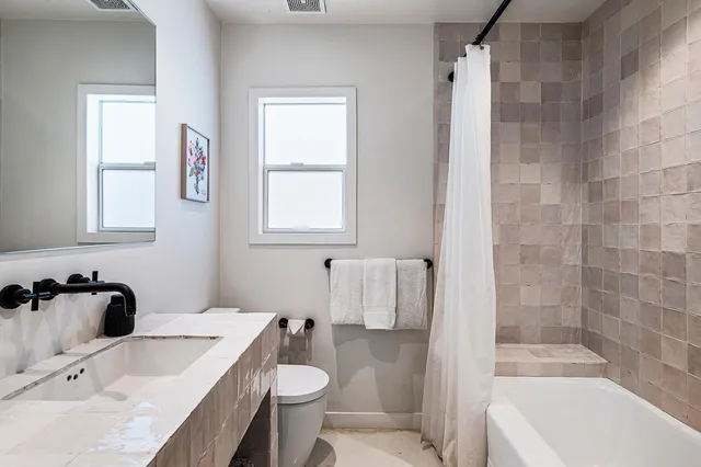 a bathroom with a sink a toilet and shower