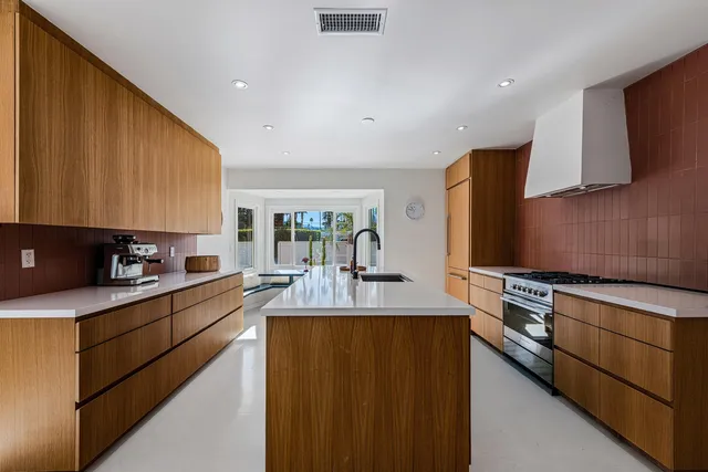 a kitchen with stainless steel appliances granite countertop a sink a stove and a refrigerator
