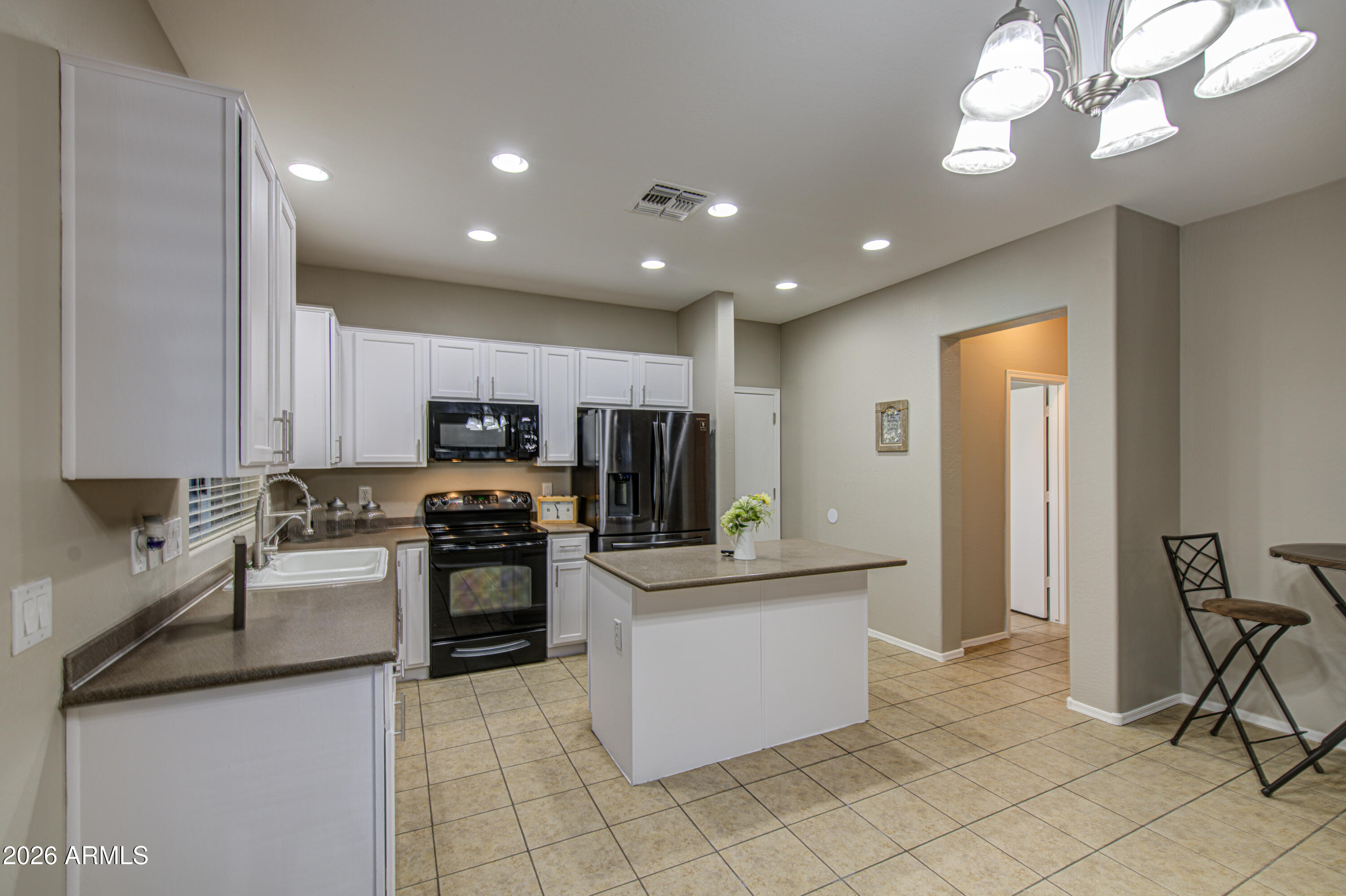 7759 West Monte Vista Road Phoenix, AZ 85035 - Photo 14 of 43 a kitchen with stainless steel appliances kitchen island granite countertop a sink and cabinets