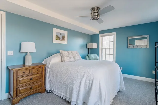 a bedroom with a bed and a lamp on dresser