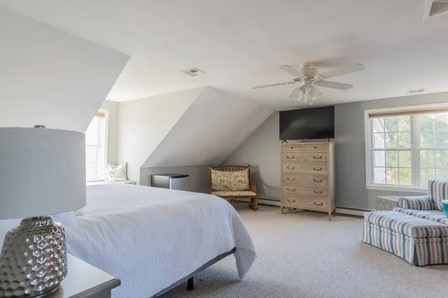 a spacious bedroom with a bed and a chair