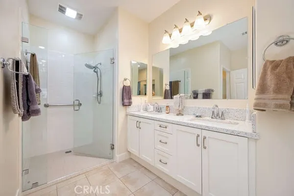a bathroom with a double vanity sink mirror and shower