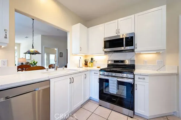 a kitchen with granite countertop a sink and steel appliances