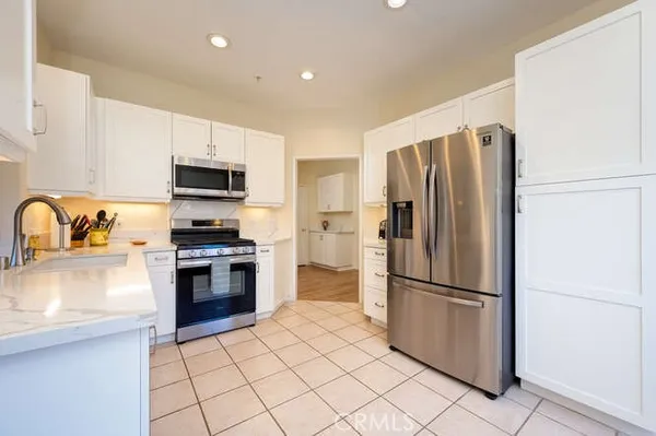 a kitchen with stainless steel appliances a refrigerator sink and microwave