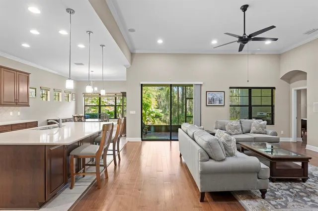 a kitchen with stainless steel appliances granite countertop a table chairs sink refrigerator and cabinets