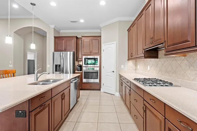 a kitchen with stainless steel appliances kitchen island granite countertop a sink stove and cabinets