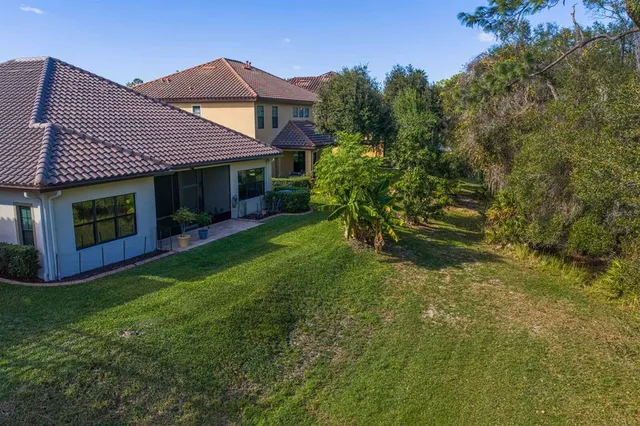 an aerial view of a house with a yard and lake view