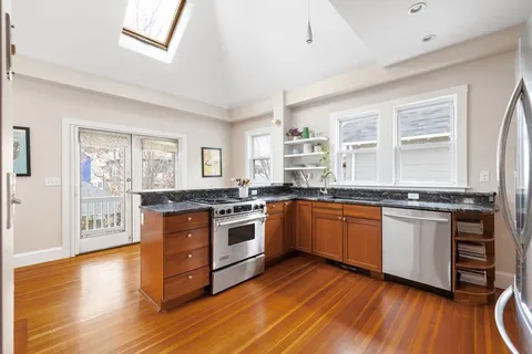 a kitchen with stainless steel appliances granite countertop hardwood floor sink and stove