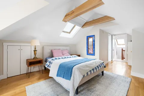 a bedroom with a large bed and a chandelier