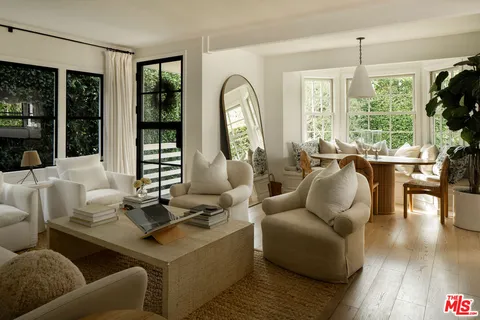 a dining room with furniture potted plants and wooden floor