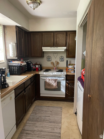 3977 Rivendell Road, Unit AB Taylorsville, UT 84129 - Photo 7 of 14 Kitchen with dark brown cabinetry, white appliances, light countertops, and under cabinet range hood