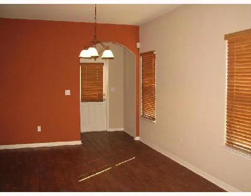 a view of a livingroom with a chandelier fan and windows