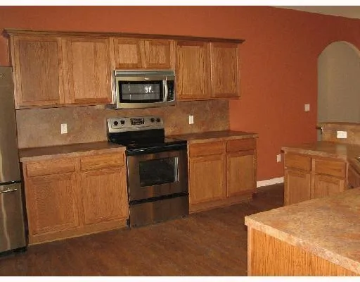a kitchen with stainless steel appliances granite countertop a stove a microwave and a refrigerator