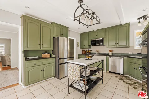 a kitchen with cabinets a sink a counter and appliances