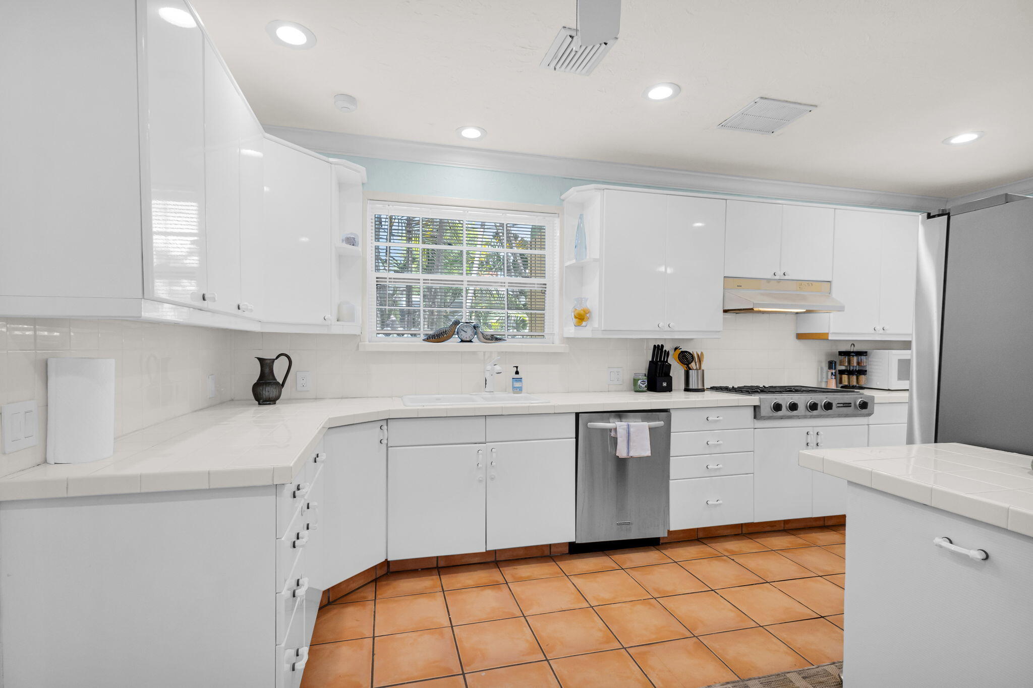 519 28th Street, Unit MAIN HOUSE West Palm Beach, FL 33407 - Photo 5 of 67 a kitchen with white cabinets a sink dishwasher and a stove with wooden floor