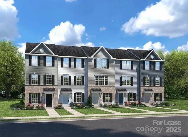 a front view of a building with street that has lawn chairs and a large tree