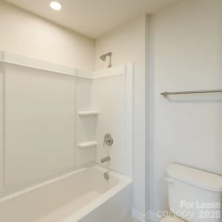 a white bath tub sitting next to a white toilet and a sink