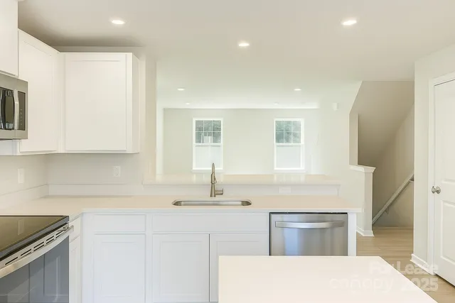 a kitchen with stainless steel appliances granite countertop a sink and a stove