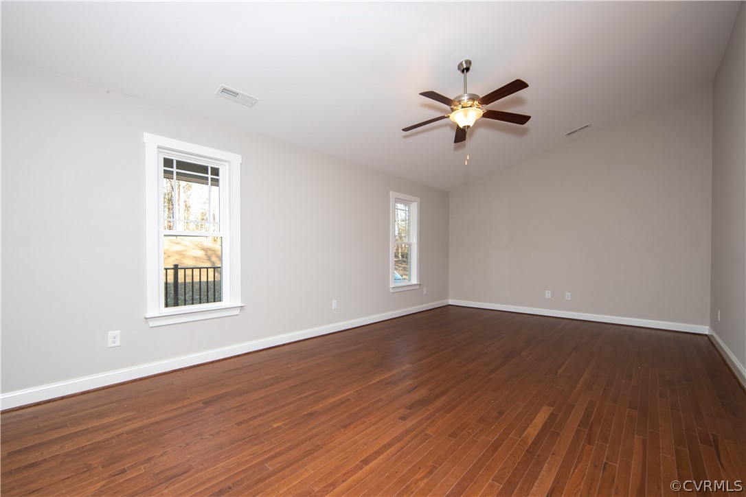 The living room boasts wood flooring, ceiling fan