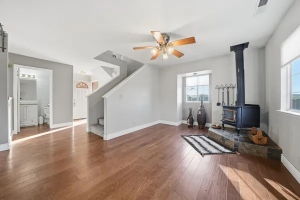 a view of a livingroom with wooden floor and a ceiling fan