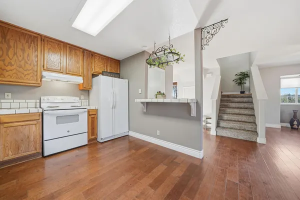 a view of a kitchen with wooden floor and electronic appliances