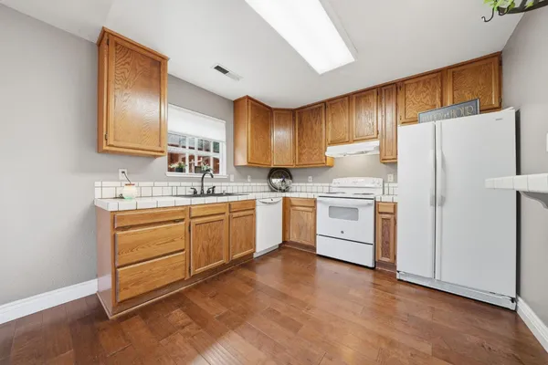 a kitchen with white cabinets and white appliances