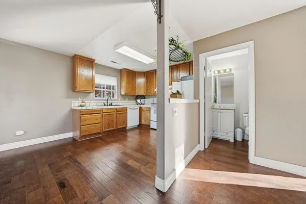 a view of a kitchen with a sink and dishwasher a refrigerator with wooden floor