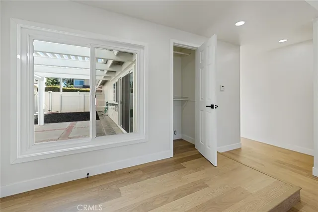 an empty room with wooden floor and a window