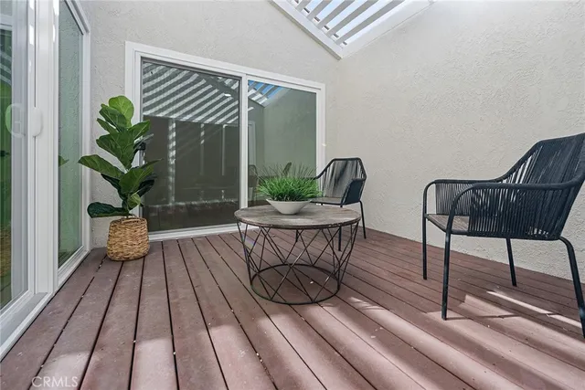 a view of a chairs and table in patio with wooden floor